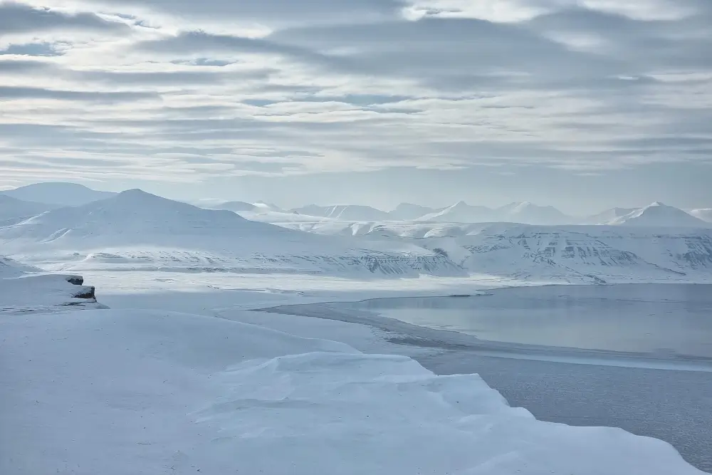 雪山に囲まれたスヴァールバルの氷の張ったフィヨルド