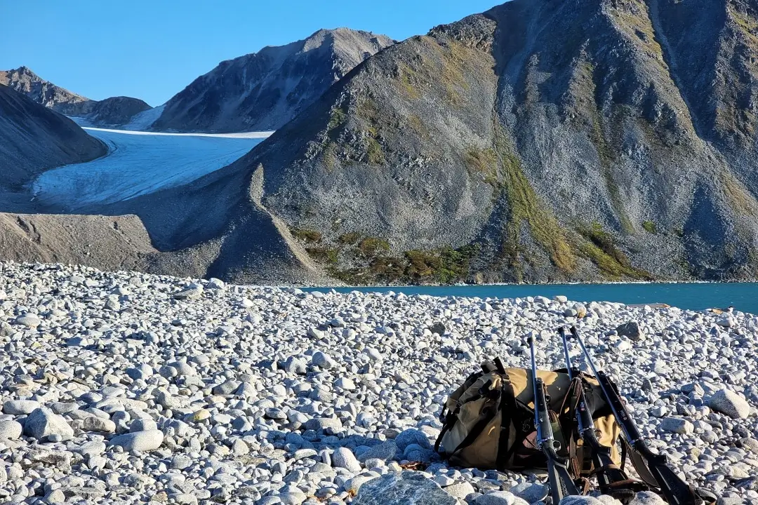 スヴァールバルの町の外で使うライフル装備と山・氷河の景色