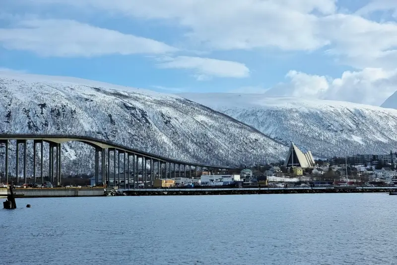 トロムソ港から見たトロムソ橋と対岸の北極教会、雪山
