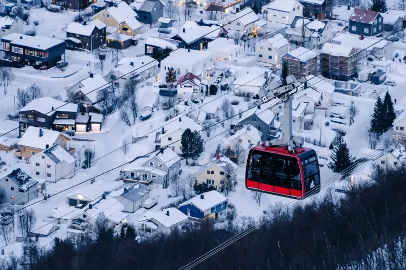雪に覆われたトロムソの街並みの上を進むFjellheisenケーブルカー