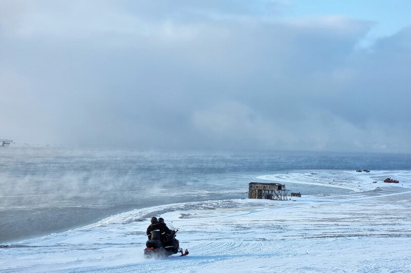 ロングイェールビーン近郊のフィヨルド沿いを走るスノーモービル