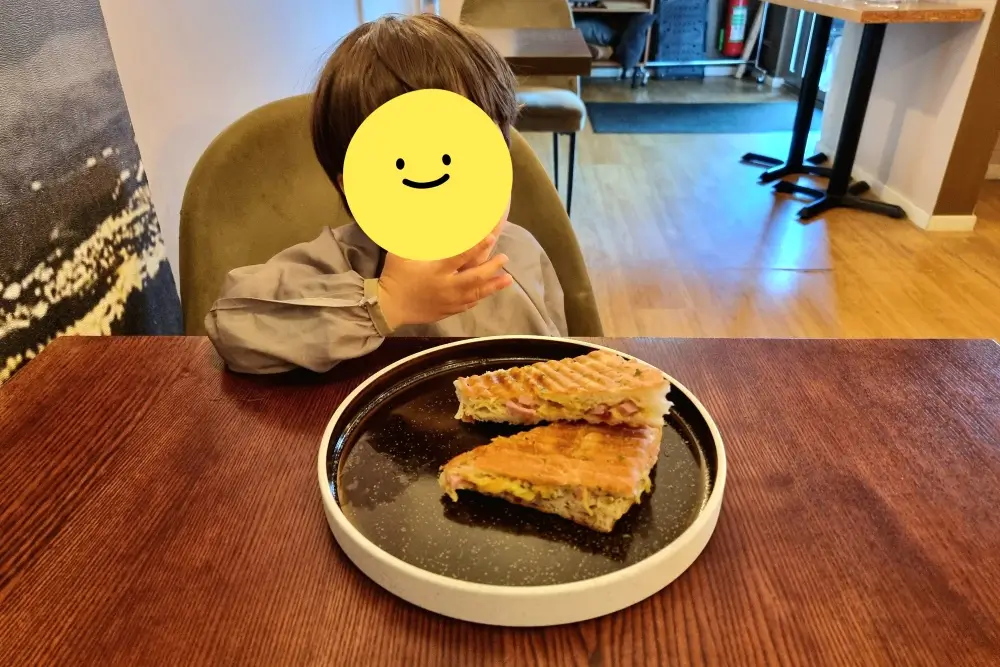 トロムソのカフェでサンドイッチの昼食を楽しむ息子