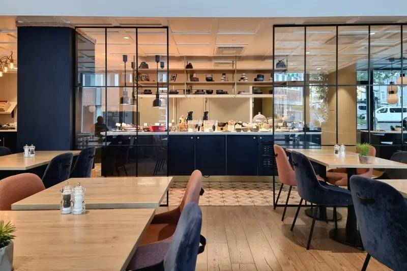 Quality Hotel Grand Tromsøのテーブル席とビュッフェカウンターがある朝食会場