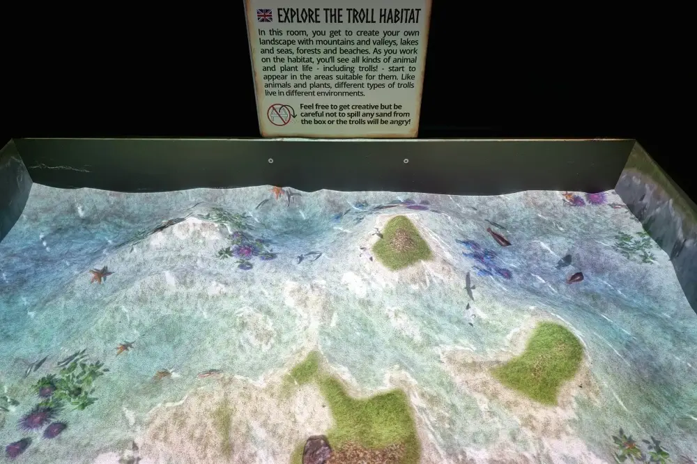 トロール博物館の砂場に投影された海や島、生き物の映像